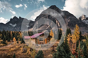 Wooden huts with rocky mountains in autumn forest at Assiniboine provincial park