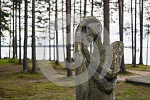 Wooden idol of woman in forest