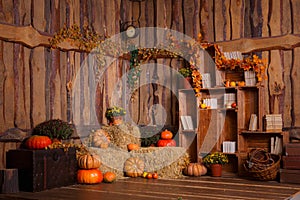 Wooden interior with pumkins, autumn leaves and flowers. Halloween and thanksgiving decoration.