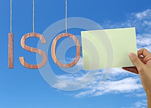 Wooden ISO text Stands for International Organization for Standardization hanging on rope.