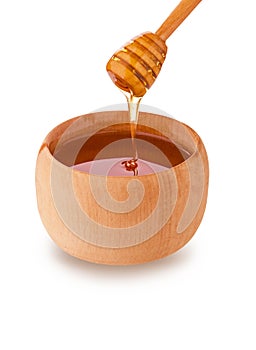 Wooden jar and honey bee dripping from dipper isolated on white background with clipping path