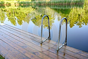 wooden jetty with bathing ladder in early morning