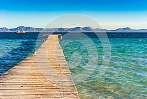 Spain Majorca island, wooden pier with sea and mountain landscape at the bay of Alcudia coast