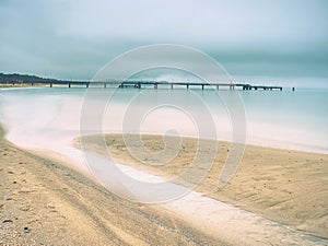 Wooden jetty and on blue lake sunset and cloudy sky