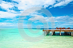 Wooden jetty with deckchairs on the background of the azure water of the Indian Ocean