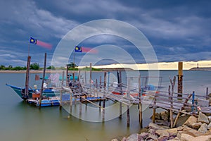 Wooden jetty with fishing boat nearly Senok Beach, Bachok, Kelantan, Malaysia