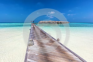 Wooden jetty towards water villas in Maldives.