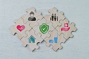 Wooden jigsaw puzzle with safety and care symbols. Healthcare concept