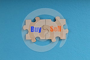 Wooden jigsaw puzzle with text BUY and SELL