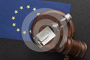 Wooden judge gavel and bottle of alcohol on EU flag background. Alcohol lawsuit in European Union concept