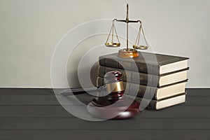 Law concept. Wooden judge gavel with law books ,scales of justice on table in a courtroom or enforcement office.