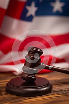 Wooden judge gavel and soundboard on american flag background