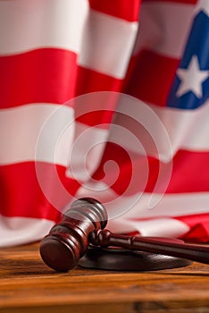 Wooden judge gavel and soundboard on american flag background