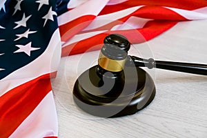 Wooden judge gavel and soundboard laying over US flag. Hammer and gavel. American law and justice concept. bidding