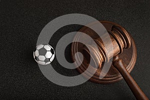 Wooden judge gavel and toy soccer ball. Football coach accused. Concussion lawsuit