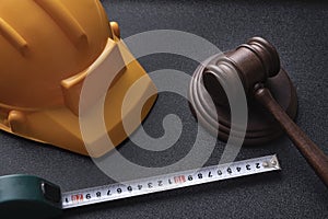 Wooden judge gavel, yellow building helmet and tape. Construction law concept. labor-related legal concept