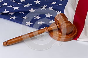 Wooden judge`s gavel on the background of the American flag. Concept: claim and compensation for damages, court session, announcem