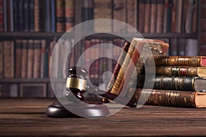 Wooden judge`s gavel and law books with treating of laws, legal issues, or cases