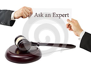 Wooden judges gavel on table in a courtroom or law enforcement office. Lawyer Hands holding business card with text Ask