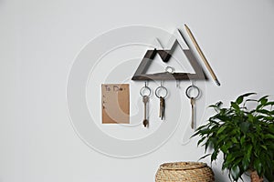 Wooden key holder and to do list on grey wall indoors. Space for text