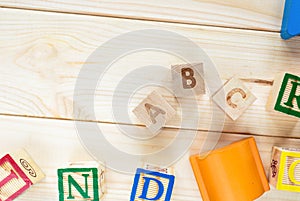 Wooden kids cubes ABC on wooden table. Educational toys blocks, pyramid, pencils, numbers. Toys for kindergarten, preschool or day