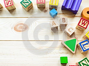 Wooden kids cubes ABC on wooden table. Educational toys blocks, pyramid, pencils, numbers. Toys for kindergarten, preschool