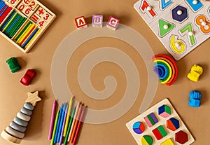 Wooden kids toys on brown paper. Educational toys blocks, pyramid, pencils,
