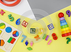 Wooden kids toys on colorful paper. Educational toys blocks, pyramid, pencils, numbers. Toys for kindergarten, preschool