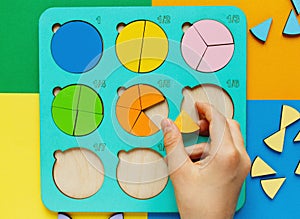 Wooden kids toys on colourful paper. Educational fractions. Toys for kindergarten, preschool or daycare.