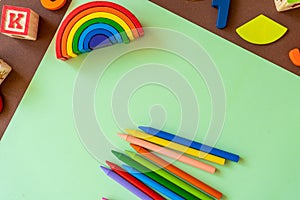 Wooden kids toys on colourful paper. Educational toys, blocks, pyramid, pencils, numbers, rainbow. Toys for kindergarten,