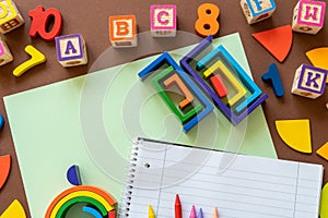 Wooden kids toys on colourful paper. Educational toys, blocks, pyramid, pencils, numbers, rainbow. Toys for kindergarten,