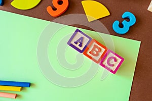 Wooden kids toys on colourful paper. Educational toys, blocks, pyramid, pencils, numbers, rainbow. Toys for kindergarten