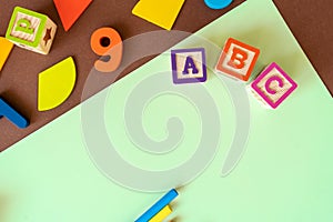 Wooden kids toys on colourful paper. Educational toys, blocks, pyramid, pencils, numbers, rainbow. Toys for kindergarten