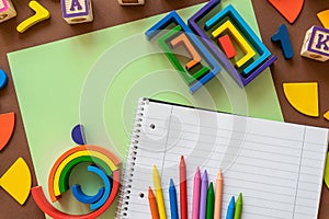 Wooden kids toys on colourful paper. Educational toys, blocks, pyramid, pencils, numbers, rainbow. Toys for kindergarten,