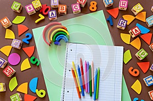 Wooden kids toys on colourful paper. Educational toys, blocks, pyramid, pencils, numbers, rainbow. Toys for kindergarten,