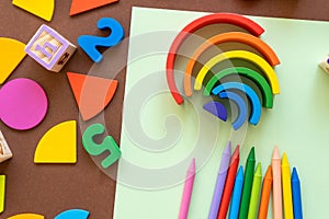 Wooden kids toys on colourful paper. Educational toys, blocks, pyramid, pencils, numbers, rainbow. Toys for kindergarten