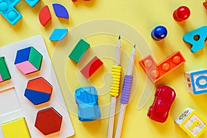 Wooden kids toys on colourful paper. Educational toys blocks, pyramid, pencils, numbers. Toys