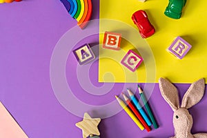 Wooden kids toys on colourful paper. Educational toys blocks, pyramid, pencils, numbers. Toys for kindergarten