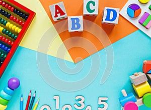 Wooden kids toys on colourful paper. Educational toys blocks, pyramid, pencils, numbers, train. Toys