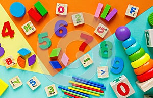 Wooden kids toys on colourful paper. Educational toys blocks, pyramid, pencils, numbers, train. Toys for kindergarten