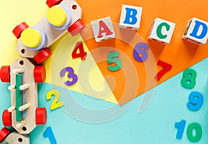 Wooden kids toys on colourful paper. Educational toys blocks, pyramid, pencils, numbers, train. Toys for kindergarten