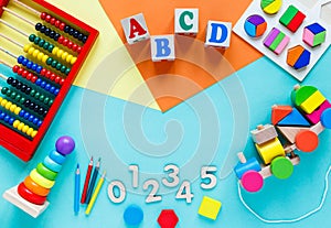 Wooden kids toys on colourful paper. Educational toys blocks, pyramid, pencils, numbers, train. Toys for kindergarten