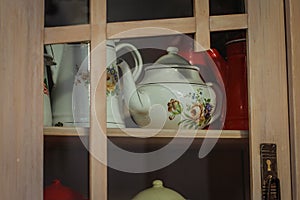 Wooden kitchen cabinet with tin pitchers and kettles