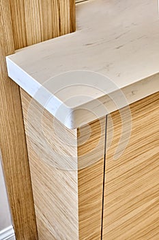 Wooden kitchen cupboard with acrylic solid surface countertop. Close-up