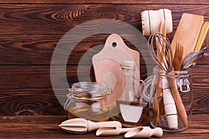 Wooden kitchen tools on a brown background