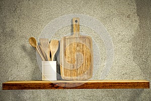 Wooden kitchen tools on wooden shelf. Copy empty space for your decoration and products. Beige brown retro wall background.