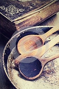 Wooden kitchen utensils on the table. Recipe book wooden spoon old pan in a retro style on wooden table