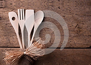 Wooden kitchen utensils on wooden background