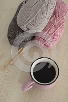 Wooden knitting needles and yarn for knitting - pink and brown. Selective focus.