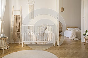Wooden ladder with beige blanket white crib real photo